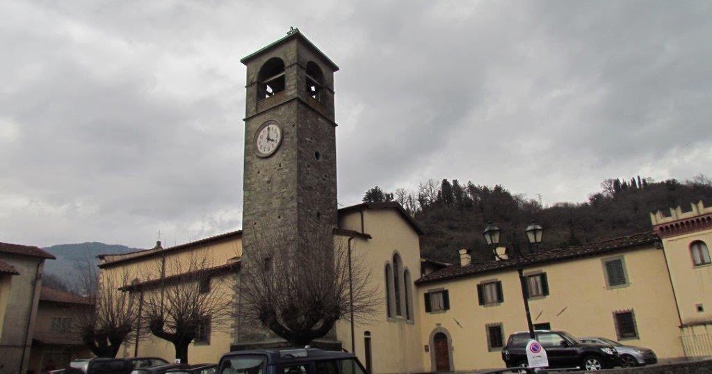 Il campanile in pietra e la facciata della chiesa parrocchiale, viste dalla piazza.